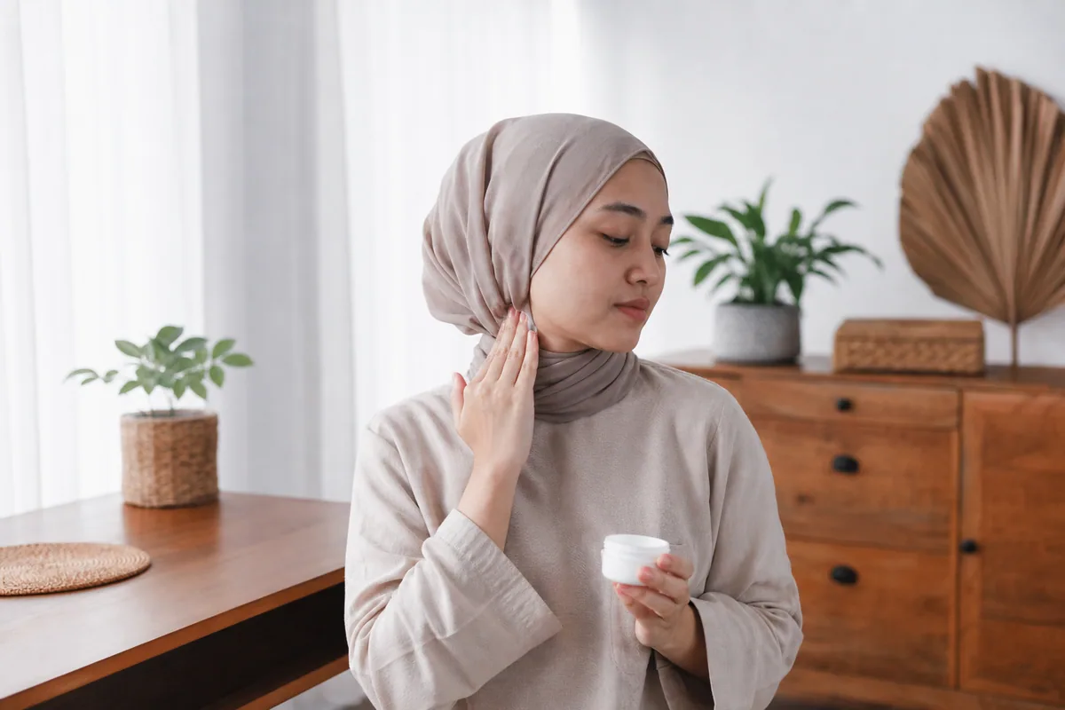 Wanita Melayu menggunakan pelembap pada bahagian belakang leher